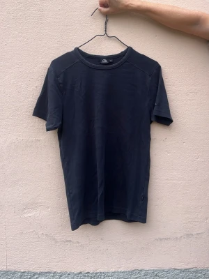 Svart basic t-shirt i bomull - En enkel svart t-shirt med rund hals och korta ärmar. Tillverkad i mjuk bomull och har en klassisk passform som funkar till det mesta. Perfekt att matcha med jeans eller shorts för en clean look.