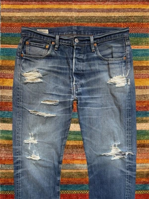 *BIG E* Levi’s 501 med Slitningar - Ett par helt otroliga Levi’s jeans under kategorin ”Big E” vilket är väldigt eftertraktat! Helt galet snygga slitningar på dessa. Storlek 33/34, utgå från måtten på sista bilden. Hör av dig vid frågor! 