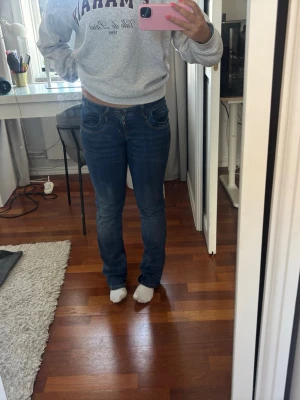 Blå raka jeans från LTB - Säljer ett par klassiska blå jeans från LTB med raka ben och normal midja. Jeansen har fem fickor, snygga sömmar och är tillverkade i ett mjukt denimtyg med lite stretch. Perfekta för en avslappnad och stilren look. I stolek w27 l32