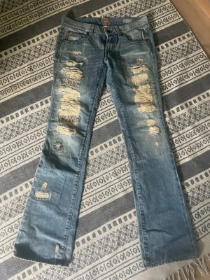 Bootcut jeans med slitning  - Ett par fina jeans med hål/slitningar på benen. Jeansen har en bootcut passform o en lägre midja❣️