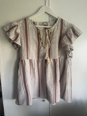 Sommrig färgglad blus  - En fin blus med snörning o ett fint randigt mönster som följer blusen💞