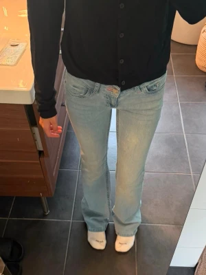 Nelly stich bootcut jeans  - Säljer ett par ljusblå jeans med bootcut passform. Jeansen har klassisk femficksdesign och är tillverkade i ett mjukt denimtyg. Perfekta för dig som gillar en avslappnad men ändå trendig look.