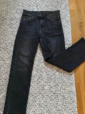 Mörka raka jeans från Replay storlek 150 - Snygga mörkblå jeans från Replay med rak passform och klassisk femficksdesign. Jeansen  är tillverkade i ett mjukt denimtyg som ger en skön känsla. Perfekta för dig som gillar en stilren och enkel look.