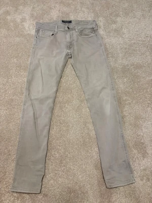 Replay anbass - Säljer ett par ljusgråa skinny jeans från Replay. Jeansen har klassisk femficksdesign, dragkedjegylf och smal passform. Materialet är mjukt och stretchigt för extra komfort. Perfekta för en clean och stilren look.