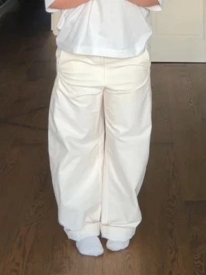 Creme barrel btxor  - Säljer ett par créme/vita jersey barrel pants från Uniqlo i storlek M! Sitter jätte bra men används tyvärr inte så mycket längre! Baksidan ser ut som på de bruna. 
