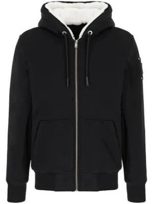 Svart hoodie med dragkedja och huva - Snygg svart hoodie med dragkedja framtill och vit, fluffig insida i huvan. Modellen har två stora fickor fram, ribbade muddar och justerbar dragsko i huvan. Perfekt för en avslappnad och cool stil.