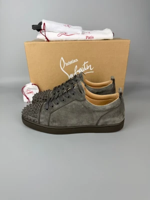 Christian Louboutin Louis Junior Spikes Sneaker Grey | 42.5 - Nästan nya grå sneakers från Christian Louboutin med spikes. Inkluderar box, dustbag, extra snören och extra spikes.