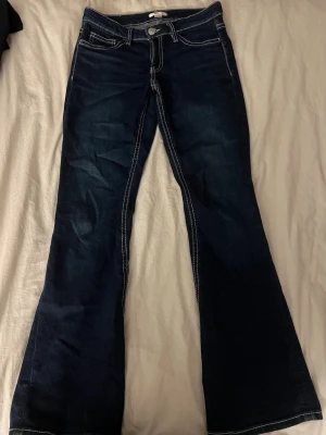 Mörkblå bootcut jeans med kontrastsömmar - Lågmidjade mörkblåa bootcut jeans med mönster på bakfickorna. Mycket bra skick, storlek 164 från Gina Tricot ❣️