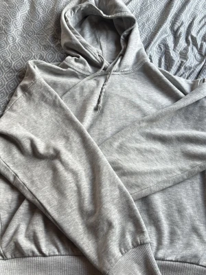 Grå hoodie från 157 med huva - Säljer en enkel och stilren grå hoodie från 157 i storlek XS. Hoodien har en klassisk huva med dragsko och mjukt, borstat foder på insidan. Perfekt för dig som gillar en clean och avslappnad look.