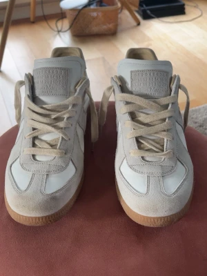 Maison margiela - Maison Margiela sneakers 👟🤍 Storlek 43📏 Vita med snygga mockadetaljer ✨ Fint skick med lätta användningsspår. Stilrena och tidlösa – passar till allt 🔥