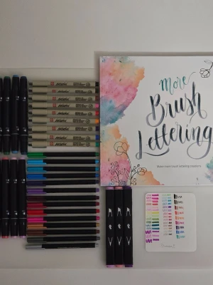 Färgpennor & målarbok Pigma + brushlettering - 🧚🏻‍♀️FÖRST TILL KVARN!🧚🏻‍♀️ Ett set med pennor från bokhandeln, flyingtiger och adlibris. Säljer för jag ska fokusera på studier och dessa har bara legat och dammat. Mesta i mycket bra skick. Pigma brush sakura pennorna är nästintill nya, knappt använda. Swatches finns på sista bild, färgerna syns tydligare. Med kommer en lettering bok i tjockt högkvalitét papper Köpt i panduro. Pigma brush set kostade 295 kr från adlibris, men vill sälja allt så snabbt som möjligt, därför billigt pris.