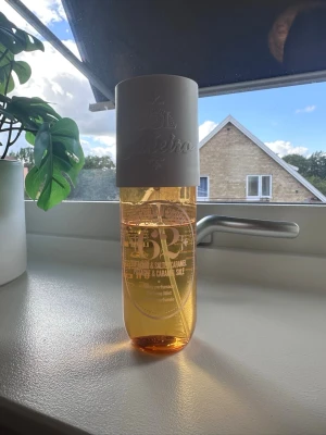 Sol de Janeiro 62 Parfym Mist - Fräsch och söt body mist från Sol de Janeiro med doft av pistage och salt karamell. Flaskan är genomskinlig med gul-orange vätska och har en vit spraykork. Perfekt för dig som gillar varma, gourmand-dofter.