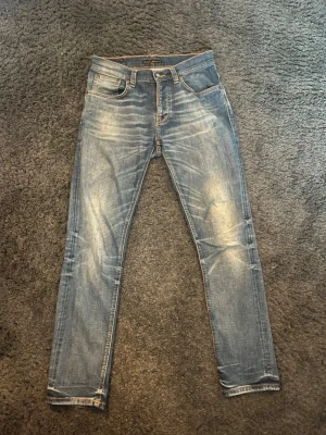 Nudie jeans grim tim - Skit snygga jeans ifrån nudie I modellen grim Tim. Jeansen har en rejäl och snygg tvätt. Dom är i storlek W30 L30. Litet hål i fickan men går att laga gratis hos närmsta nudie butik