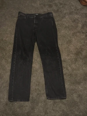 Svarta raka jeans - Säljer ett par svarta jeans med rak passform och klassisk femficksdesign. Jeansen har normal midja och är tillverkade i denim. Perfekta för dig som gillar en enkel och stilren look.