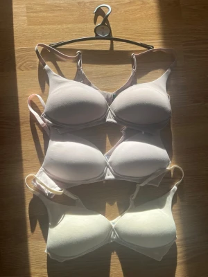 3-pack bh aldrig använda - Säljer tre bhar med justerbara axelband och utan bygel. Alla bhar har en mjuk och slät yta utan spets eller mönster, vilket gör dem bekväma under tighta plagg. Materialet ser ut att vara bomullsmix eller mikrofiber för extra komfort. Aldrig använda, endast testade, säljer pga fel storlek för mig.