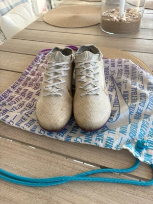 Beige Nike fotbollsskor med blå detaljer - Sökjer ett par Nike Limited edition elite fotbolssskor som är u bra klick där elite påsen ingår. Perfekt för dig som vill prestera på högsta nivån