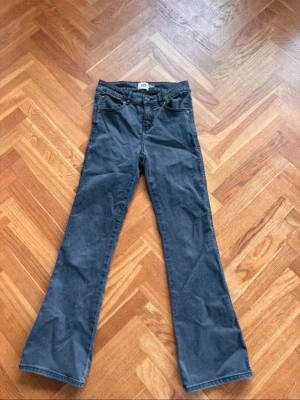 jeans - Snygga  bootcut jeans med klassisk  justerbar midja med knappresår. Jeansen har en rak passform upptill och utsvängda ben, perfekta för en avslappnad och trendig look. Skulle säga midwaist, storlek 160! 
