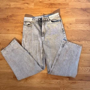 Ljusgrå jeans från weekday - Säljer ett par ljusgrå jeans med rak passform och hög midja.                                                                               Materialet är denim i en tvättad look som ger en avslappnad vibe. Perfekta till en streetwear-outfit eller casual stil.                                                                                       Storlek:28/30