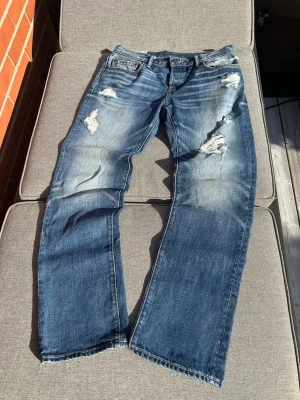 Abercrombie and Fitch jeans - Riktigt snygga vintage Abercrombie and fitch jeans nu till hösten och vintern. Trevliga slitningar och fades, på låren och över byxfickan. Ett par som nästan ingen annan har. Storlek:W30L30.                       Hör av er om ni undrar något!