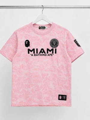 BAPE x Miami t-shirt - Limited edition rosa t-shirt från BAPE x Miami med svart tryck fram och bak. T-shirten har ett subtilt kamouflagemönster, rund hals och korta ärmar. Materialet är mjuk bomull. Storlek L men passar även M. Kom med frågor och prisförslag!☺️
