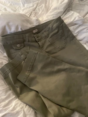 Olivgröna raka jeans helt oanvända från nelly jeans - Snygga olivgröna jeans med raka ben och klassisk femficksdesign. Jeansen har en knapp och dragkedja framtill samt en extra ficka med lock på ena sidan. Tillverkade i ett mjukt bomullsmaterial som är bekvämt att bära.