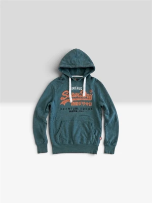 Grön Superdry hoodie  - Snygg grön hoodie från Superdry med stort orange och vitt tryck på bröstet. Klassisk känguruficka framtill, vita dragsnören i huvan och ribbade muddar. Perfekt för en avslappnad streetwear-look.
