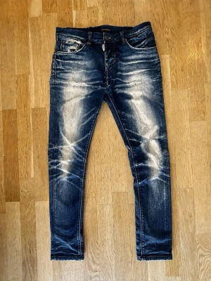 Antony Moraio jeans  - Säljer ett par blå skinny jeans med slitningar och tvättade detaljer på både fram- och baksida. Jeansen har klassisk femficksmodell, låg midja och smal passform. Materialet är denim i bomull med stretch för extra komfort.