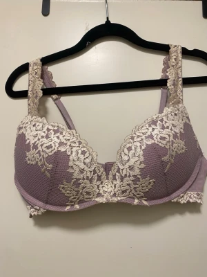 Ljuslila bh med spetsdetaljer från intimissimi - Säljer en ljuslila bh med vadderade kupor och vacker beige spets över hela framsidan och axelbanden. Bh:n har bygel och breda axelband för extra stöd. Perfekt för dig som gillar romantiska detaljer och mjuka färger. Tyvärr för stor för mig.
