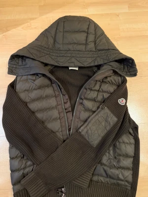 Moncler cardigan  - (Moncler cardigan med luva) färgen är grön och själva jackan är välomhändertagen, priset är diskuterbart så tveka inte på att slå en signal!! 