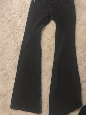 Svarta lågmidjade utsvängda jeans - Snygga svarta lågmidjade jeans med utsvängda 