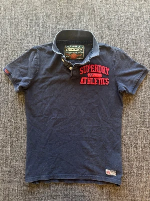 Superdry pike ~ sällsynt  - 🎉 20% rabatt om du följer min profil och handlar direkt! 😊  Sjukt sällsynt Superdry piké i storlek S – marinblå vintage tvättad 2000’s modell med snygg sliten look och hög kvalitet. En eftertraktad modell som inte längre produceras och passar perfekt året om. 📦 Skickas inom 24h, kan gå ner lite i pris vid snabb affär! ✌️