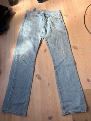 Levis jeans - Säljer ett par ljusblå jeans med rak passform och klassisk femficksdesign. Jeansen har normal midja och är tillverkade i denim med en snygg tvättad look. Perfekta för en avslappnad och trendig stil. Storlek 30/32