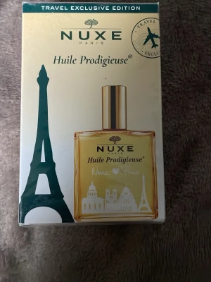 Nuxe Huile Prodigieuse torr olja - Nuxe Huile Prodigieuse är en multifunktionell torr olja för ansikte, kropp och hår. Innehåller 7 botaniska oljor och har en ikonisk doft. Kommer i en exklusiv Paris-inspirerad förpackning med guldfärgad flaska och lock.