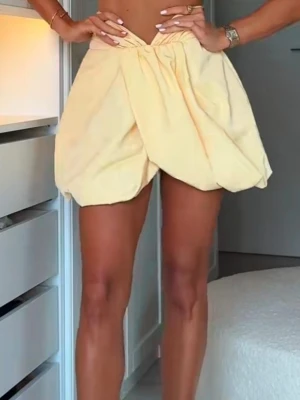 Gul kort ballongkjol med volang från zara - Trendig gul kortkjol med ballongformad siluett och volangdetaljer upptill. Kjolen har en hög midja och är perfekt för dig som vill sticka ut med en unik look. Tillverkad i ett mjukt tyg som ger en snygg och bekväm passform.