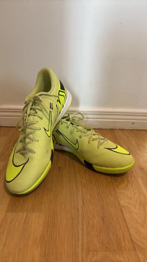 Fotbollsskor för futsalbruk från nike - Nu säljer jag ett par futsalskor från nike! Skorna är neongröna som det syns i bilden och är i nytt skick! Använt tre gånger och funkat utmärkt. Skorna är sköna och bra att använda på gym till och med. Ny pris ligger på ca 1200 kr! Storleken är 44 men är liten i storleken så passar även mindre fötter. 