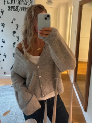 Grå  kofta med knappar - Mysig grå kofta med v-ringning och knappar framtill. Koftan har en avslappnad passform som ger en cool och trendig look. Perfekt att slänga över ett linne eller t-shirt. 💗💗
