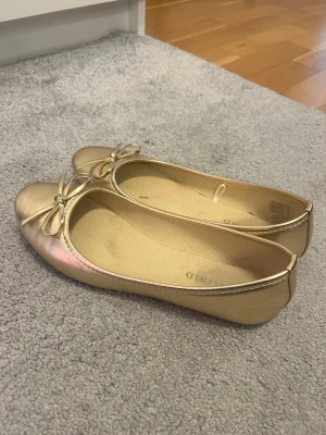 Guldiga ballerinaskor från Anna Field - Snygga ballerinaskor från Anna Field! De är lite smutsiga inut men väldigt fina utanpå. De är endast anvädna 2 gånger!