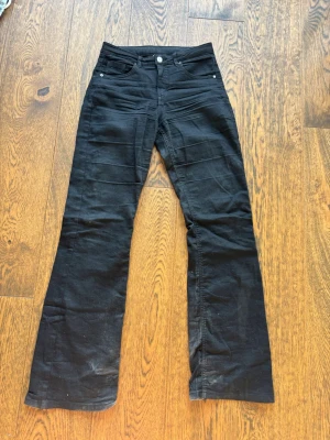 Svarta bootcut jeans från Kappahl - Snygga svarta bootcut jeans från Kappahl i storlek 170! Jag tycker de sitter snyggt och passar bra på mig som är 155! Även dessa har lite slitning längst ner i benen! 