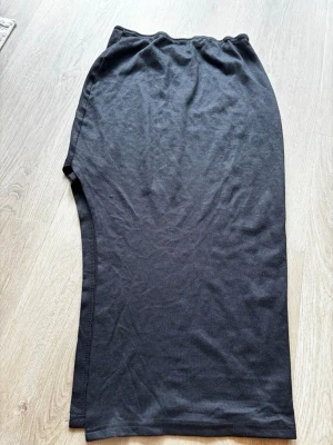 Svart långkjol från SHEIN - En enkel och stilren svart långkjol från SHEIN i mjukt och stretchigt material. Kjolen har rak passform och är tillverkad i polyester med lite elastan för extra komfort. Perfekt att matcha med en crop top eller hoodie.