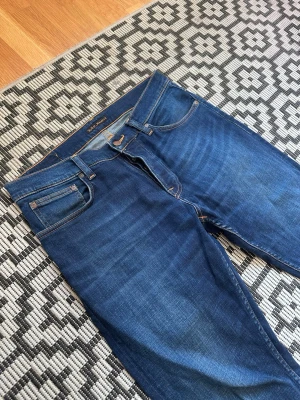 Nudie Jeans ”Grim Tim” - Säljer ett par riktigt fräscha och nästan helt nya jeans ifrån ”Nudie Jeans” Modellen heter ”Grim Tim” och är ett par slim jeans i färgen ”Indego Blue”. Dessa jeans är väldigt populära för sin kvalité och hur bra som sitter! Storleken är W34L32. Hör av er vid intresse! 🫡