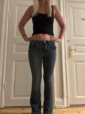 Mörkblå bootcut jeans - Säljer ett par mörkblå bootcut jeans med låg midja. Jeansen har en snygg tvätt och sitter tight över låren för att sedan bli vidare nedtill. Perfekta till en avslappnad och trendig look. Byxorna är använda ett fåtal gånger, byxorna är i storlek 36
