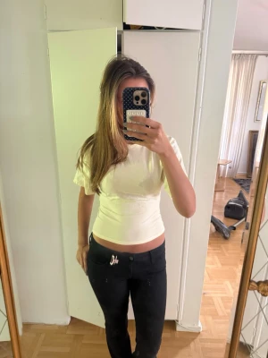 Vit croppad t-shirt med kort ärm - Snygg vit croppad t-shirt med korta ärmar och rund hals. Den har används några gånger men inget tecken på användning