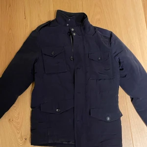 Mörkblå fieldjacket - Fieldjacket från Riley i 10/10 skick. Storlek M. Perfekt nu på hösten. Pris 600 eller bud