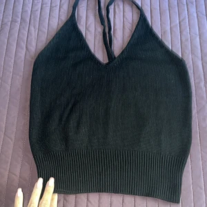 Svart stickad linnetopp från Gina Tricot - Säljer en snygg svart stickad linnetopp från Gina Tricot. Toppen har en v-ringad design med smala axelband och en ribbad nederkant. Perfekt för både vardag och fest!