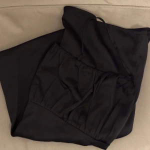 Svart klänning med slits - Säljer en elegant svart klänning med smala axelband och en snygg slits framtill. Storlek 40, jag är en S/M 🤍