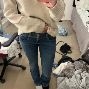 Säljer ett par skitsnygga blå lågmidjade bootcut jeans. De är i bra skick med lite små defekter. De är gjorda i ett bekvämt denimtyg som sitter skönt hela dagen. Köpta second hand i london🩷