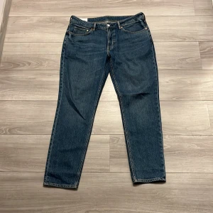 Blå jeans från H&M - Säljer ett par snygga blå jeans från H&M i modellen 'Regular tapered'. De har en klassisk femficksdesign och är perfekta för vardagsbruk. Jeansen är i bra skick och har en bekväm passform. Skriv vid frågor eller funderingar😇