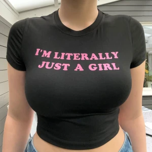 Svart t-shirt croptop med rosa tryck im literally just a girl - Söt svart crop top med rosa roligt tryck im just a girl. Babytee i en mjuk och bekväm kvalitet. Storlek M tajt passform. Helt ny och aldrig använd