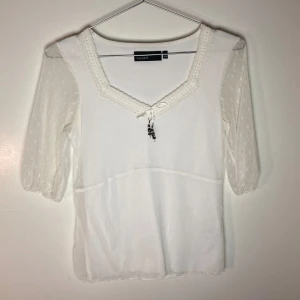 Vit blus med spets detaljer - Vit blus med snörning och spets detaljer och ärmar.  Står ingen storlek men uppskatar s på den större sidan