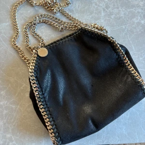 Stella McCartney väska - Köpt begagnad från börjaan därav Inget kvitto eller dustbag. Väl använd, därav lite slitningar på kedjan och på själva väskan. Annars fint skick, bara fråga om mer bilder!